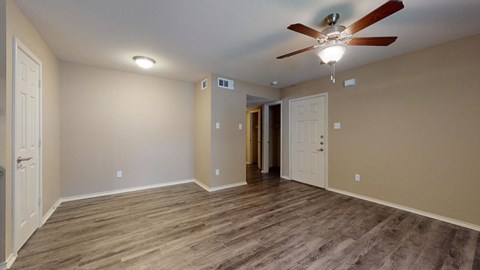 a living room with wood floors and a ceiling fan